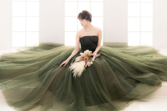 グリーンのカラードレスを着て座る新婦