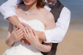 海辺で抱き合うカップルの手元