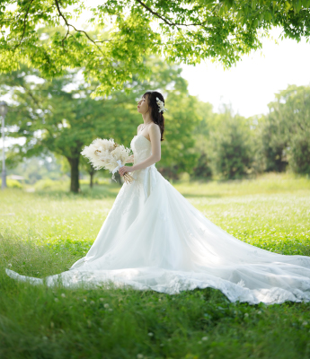 新緑の中で佇むウェディングドレスの新婦